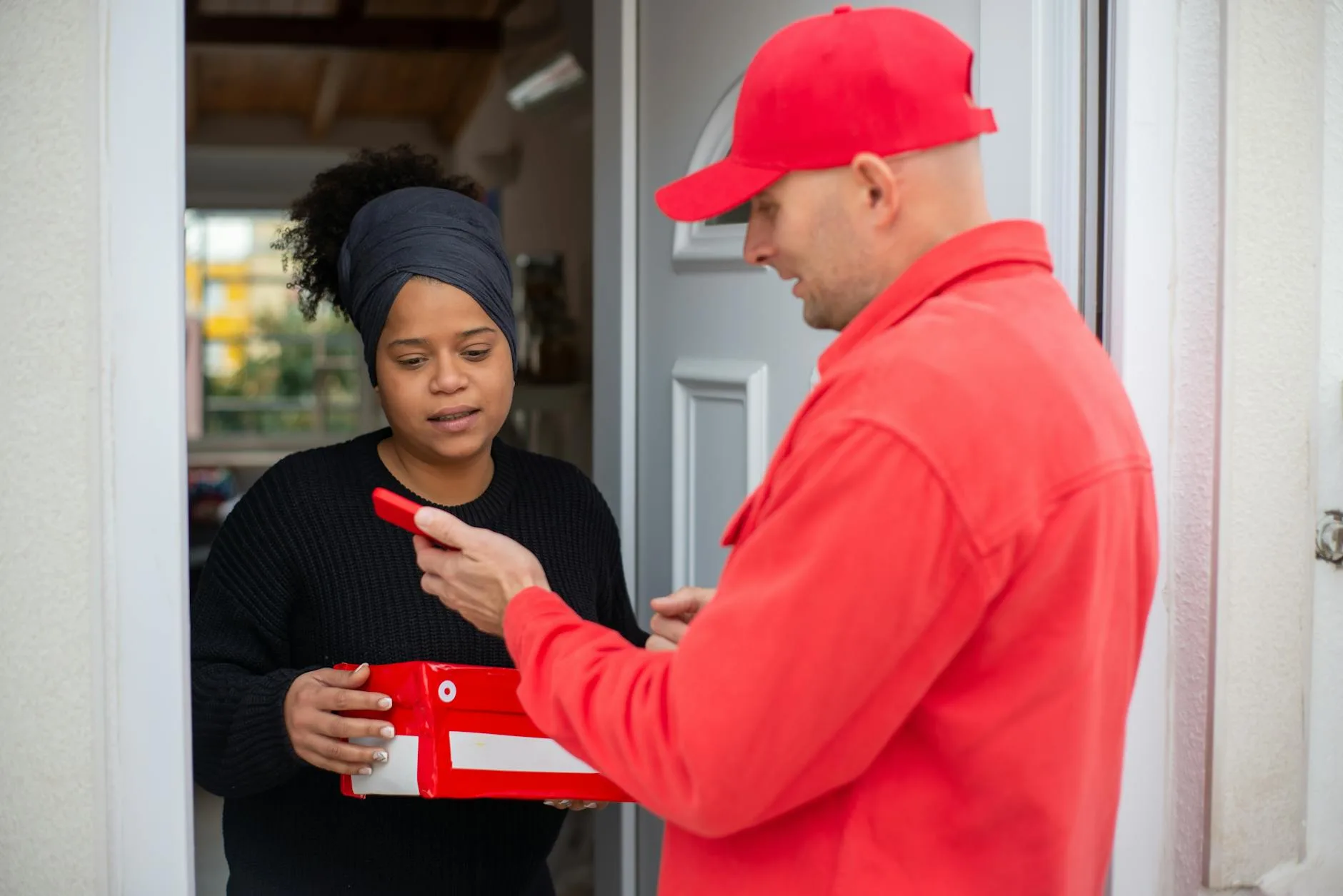Person approaching a front door with a delivery parcel