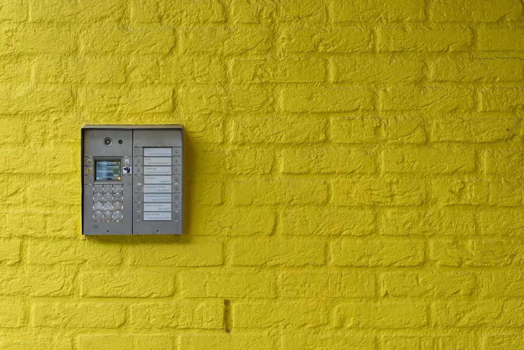 Smart home alarm keypad mounted on wall in modern hallway