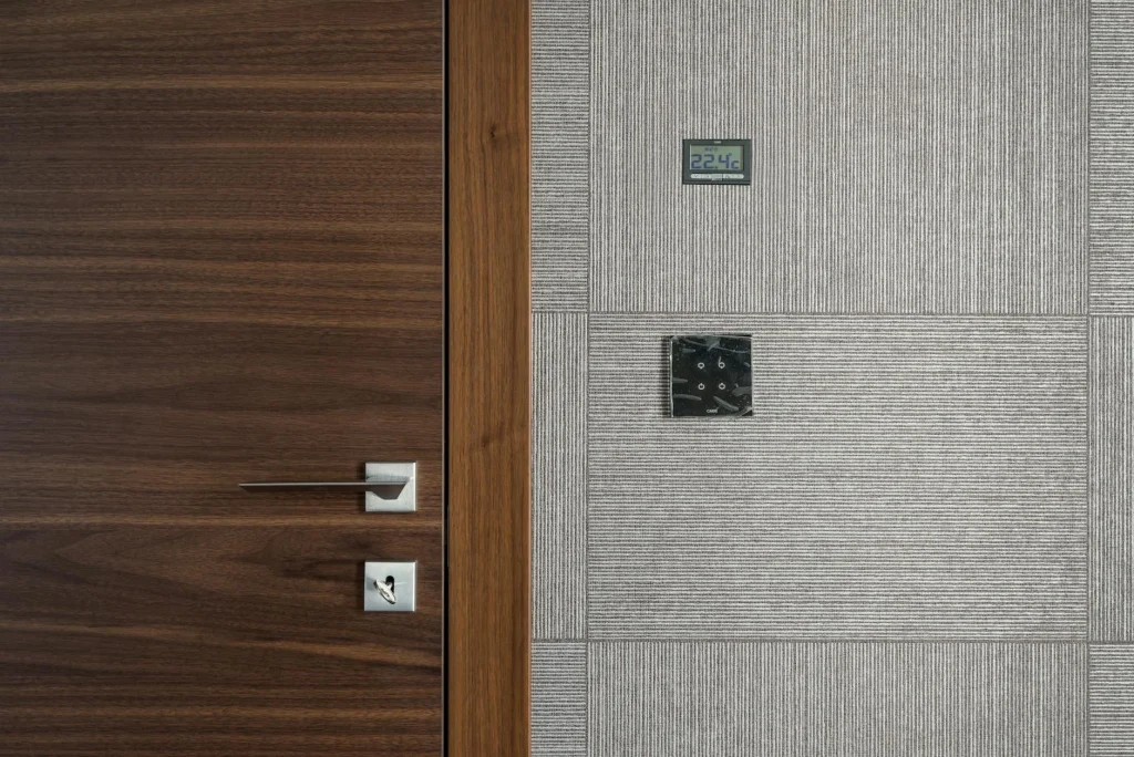 Smart thermostat mounted on a wall showing temperature display