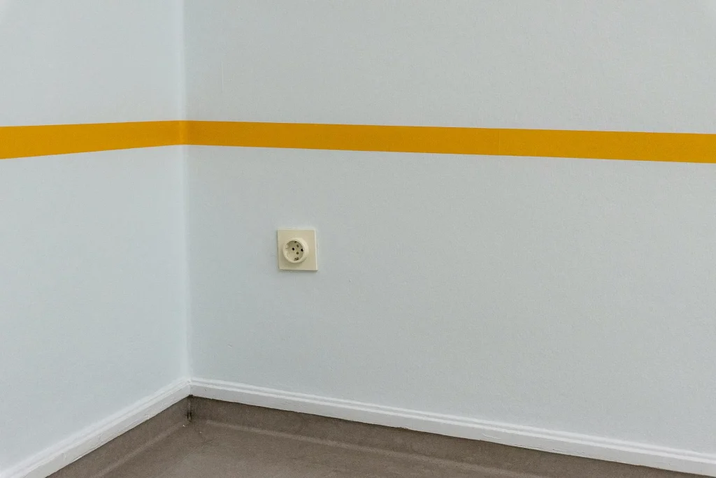 White electric plug inserted into a wall socket